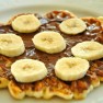 Whole wheat waffles with oats topped with some chocolate spread and banana